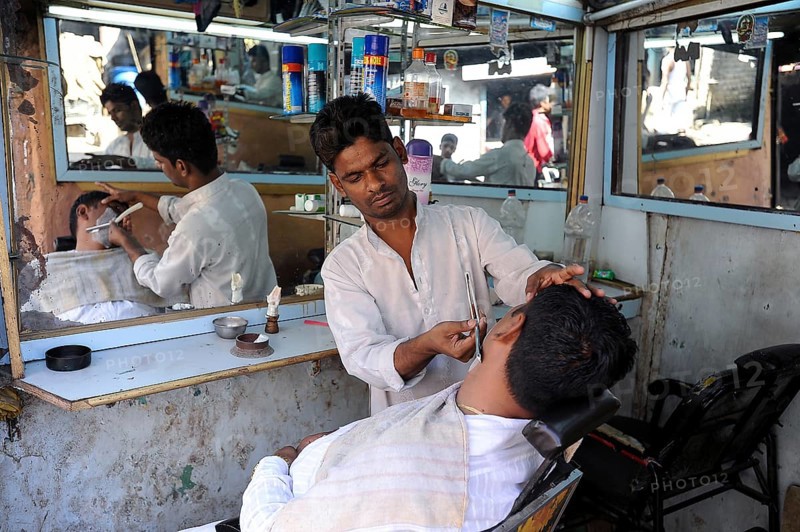 08.12.2011, Mumbai, Maharashtra, India, Asia, A barber shaves a customer in a small men's parlour in the Dharavi slum of Mumbai, Asia