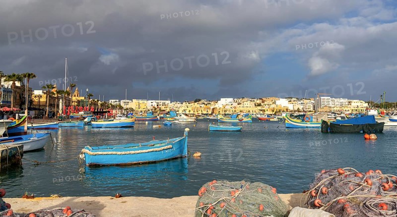 Marsaxlokk, Malta, 22 December, 2023: colorful fishing boats in the harbor of Marsaxlokk in southeastern Malta, Europe