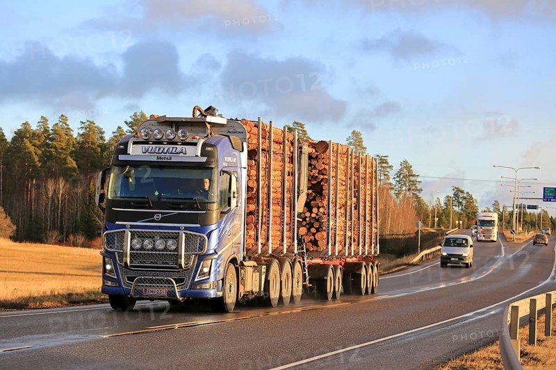 KAARINA, FINLAND, DECEMBER 5, 2016: Blue Volvo FH16 of Vuotila Oy for wood transport on the road with full timber load on a winter afternoon light