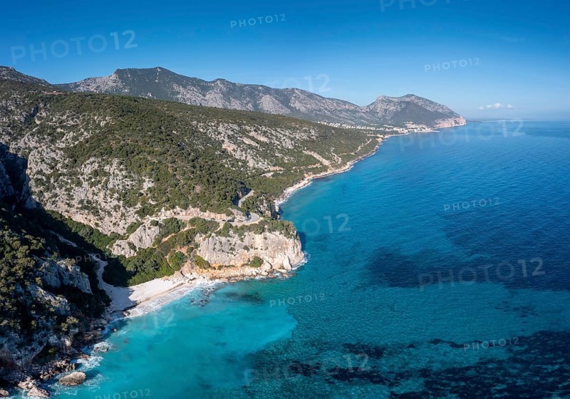Aerial view of the rugged mountainous coast near Cala Gonone with turqouise water and small white sand beaches