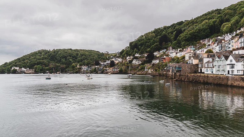Dartmouth, Devon, England, UK, May 26, 2022: The bank of the River Dart with some boats and the southern part of Dartmouth