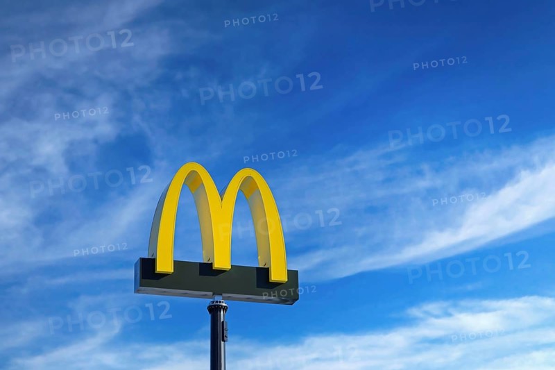 McDonald's logo against blue sky and white fair weather clouds at McDonald's restaurant in Salo, Finland. March 12, 2023