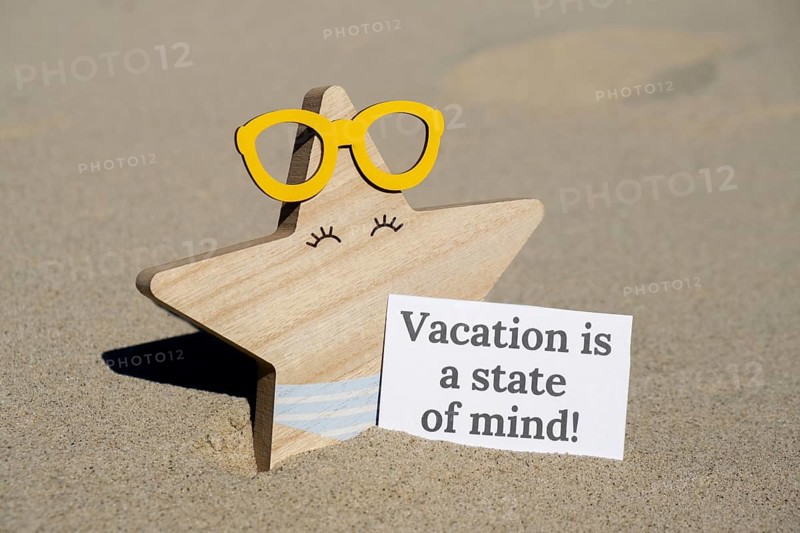 VACATION IS A STATE OF MIND text on paper greeting card on background of funny starfish in glasses summer vacation decor. Sandy beach sun coast. Holiday concept postcard. Getting away Travel Business concept