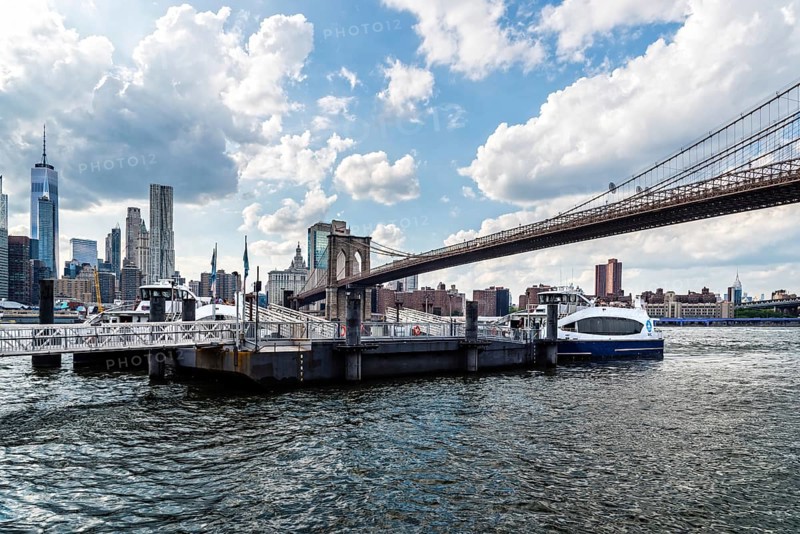 New York City, USA, June 24, 2018: Pier in East River Against Cityscape of Downtown of Manhattan and Brooklyn Bridge. Travel to New York and Transportation, North America
