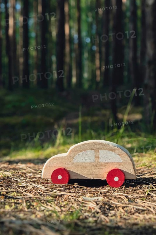 Wooden toy car on greenery forest background. Eco-car concept World car free day electric vehicle environment automobile transportation electric vehicle. Hybrid electric. Sustainable engine. Zero CO2 emission for natural awareness and green environment pollution concept