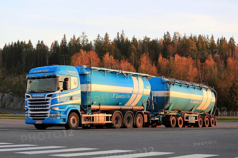FORSSA, FINLAND, OCTOBER 17, 2015: Blue and white Scania R580 double tanker of E.Laurila Oy parked on truck stop in evening light with trees in autumn colors on the background