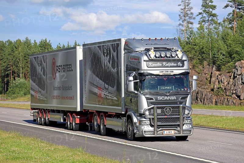 PAIMIO, FINLAND, JULY 3, 2016: Steel grey Scania R560 combination vehicle of Karelia Kuljetus Oy moves along motorway in South of Finland on a beautiful summer evening