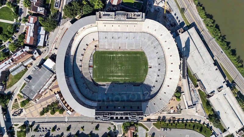An aerial view of Neyland Stadium reveals a massive, iconic structure nestled by the Tennessee River, with its distinctive bowl shape and seating for over 100, 000 fans, showcasing its rich football heritage