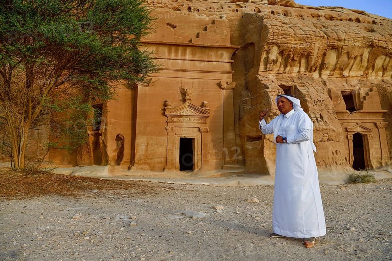 Rawi, storyteller, in front of the Nabataean tombs at the rock Qasr Al-Bint, Hegra or Madain Salih, AlUla region, Medina province, Saudi Arabia, Arabian Peninsula, Asia