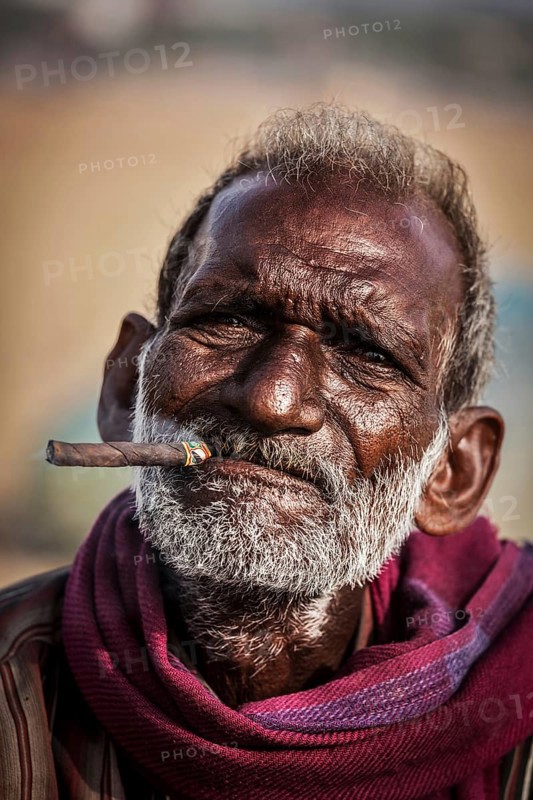 CHENNAI, INDIA, FEBRUARY 10, 2014: Unidentified old fisherman smoking on Marina beach in Chennai, Tamil Nadu, India, Asia
