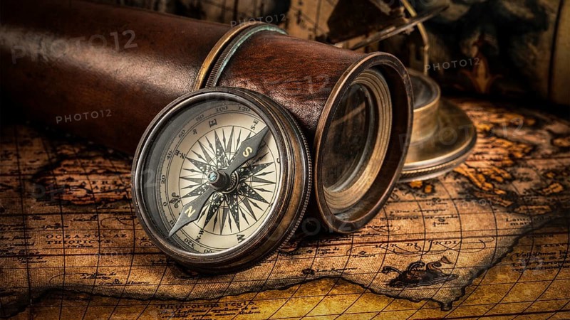 Travel geography navigation concept background, panorama of old vintage retro compass with sundial, spyglass and rope on ancient world map
