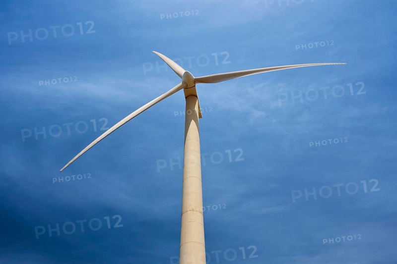 Green renewable alternative energy concept, wind generator turbine generating electricity in blue sky