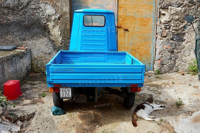 Ape, motorised tricycle, light blue, from behind, yard, Rinella, town on the south coast, Salina, Aeolian Islands, Lipari Islands, Sicily. Italy