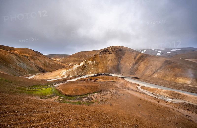 Bridge over steaming stream between colourful rhyolite mountains with snowfields, Hveradalir geothermal area, Kerlingarfjöll, Icelandic highlands, Iceland, Europe