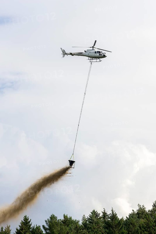 Symbolic image, climate change, helicopter, helicopter spreading finely painted limestone and wood ash against acid rain, mixed forest, container, soil protection liming, forest liming, Baden-Württemberg, Germany, Europe
