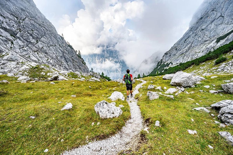 Mountaineer on a hiking trail, cloudy mountains, descent over the Ofental, mountain tour on the Hochkalter, Hochkalter crossing, Berchtesgaden Alps, Bavaria, Germany, Europe
