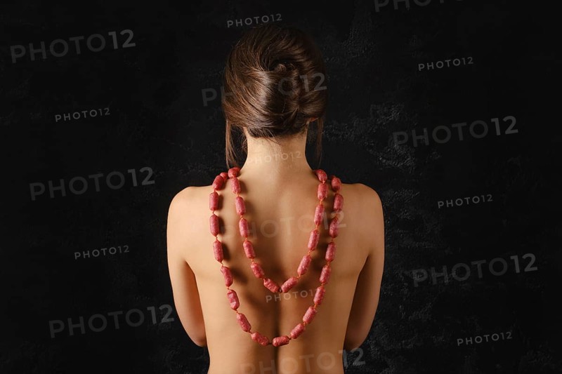 Young woman wearing small piccolini sausages with spices as a beads