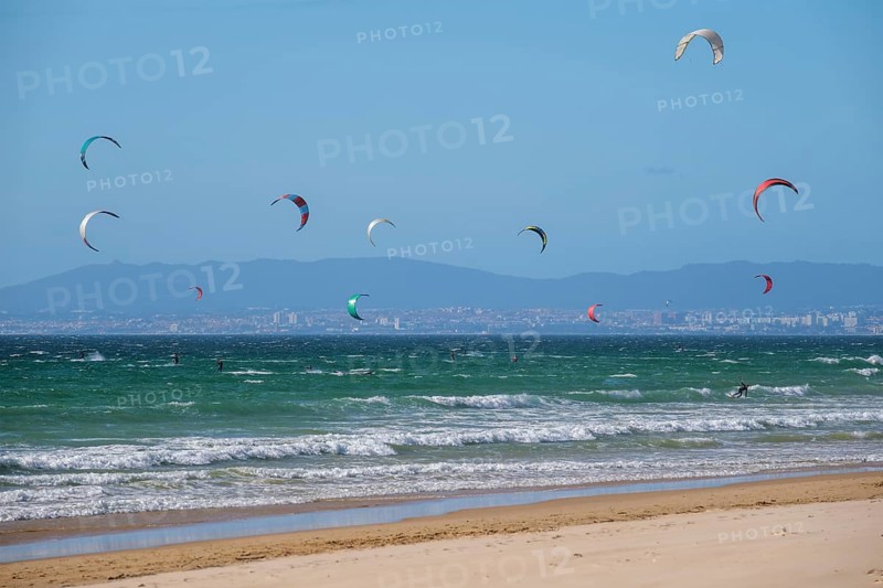 Kiteboarding kitesurfing kiteboarder kitesurfer kites on the Atlantic ocean beach at Fonte da Telha beach, Costa da Caparica, Portugal, Europe