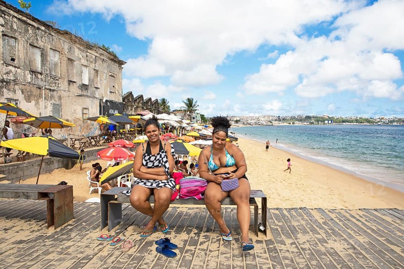 Brazilian woman, 22, on a bench at Praia da Boa Viagem beach, Salvador, Bahia state, Brazil, South America
