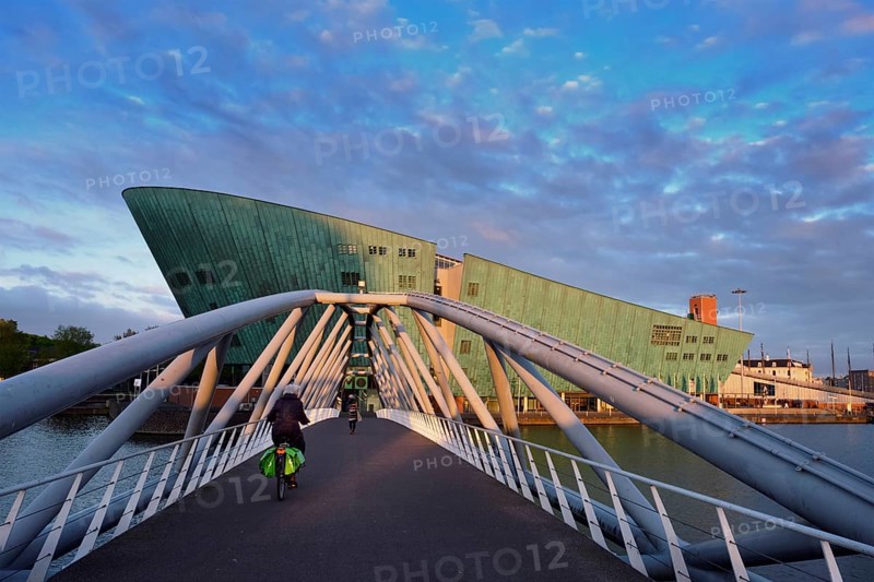 AMSTERDAM, NETHERLANDS, MAY 9, 2017: NEMO Science museum and Mr. J. van der Veldebrug bridge. It is the largest science center in Netherlands with over 500000 visitors per year