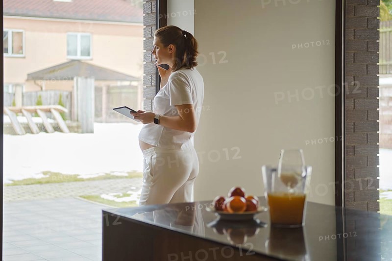 Attractive pregnant woman calls a doctor for an online consultation or to find out the results of tests. Pregnancy and new technology health care concept