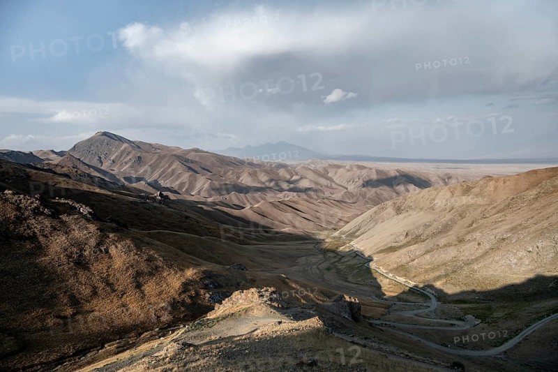 View of mountain landscape and pass road at Tyibel Pass, Song Kul Too mountain range, Naryn region, Kyrgyzstan, Asia