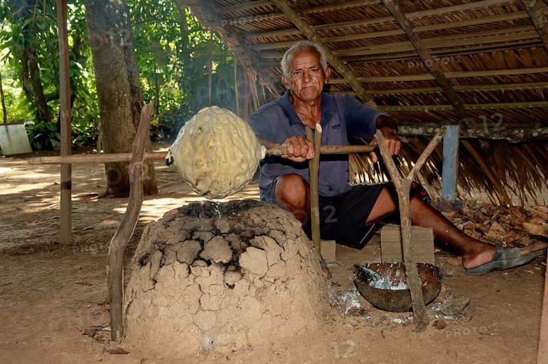 Man of a Caboclos tribe heating up a rubber ball, Amazon state, Brazil, South America