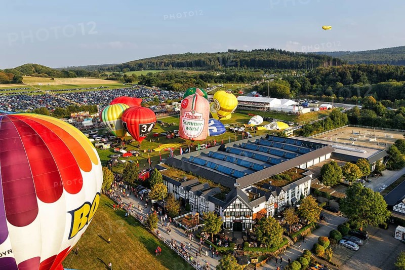 Colourful hot air balloons at mass launch, crowd on fairground, Hot Air Balloon Festival, 26th Warsteiner International Montgolfiade, aerial view, Warstein, Sauerland, North Rhine-Westphalia, Germany, Europe