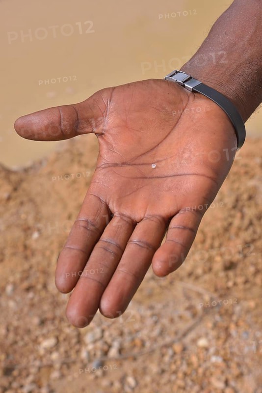 Hand of a diamond hunter displaying a diamond, near Koidu, Koidu-Sefadu, Kono District, Eastern Province, Sierra Leone, Africa