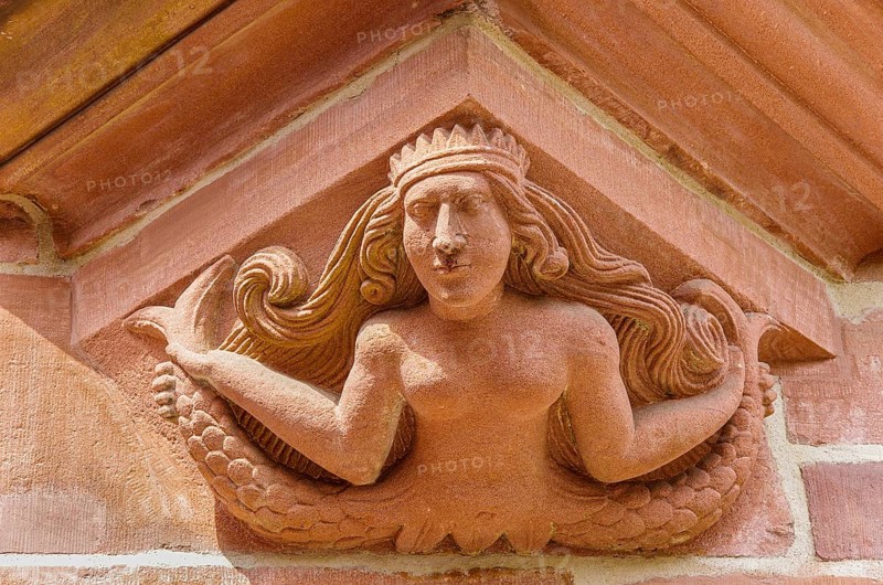 Supporting and ornamental architectural detail in the form of a bare-breasted mermaid on the south-eastern corner oriel of the New Town Hall on Rathausplatz Freiburg im Breisgau, Baden-Württemberg, Germany, Europe