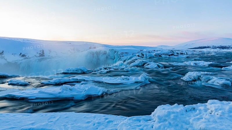 Icefall at the edge of the Godafoss waterfall at dawn, snow-covered landscape, Northern Iceland Eyestra, Iceland, Europe