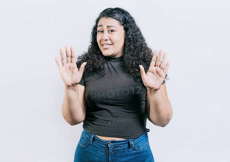 Woman with face disgusted raising hand isolated. Girl with disgust face isolated. Latin girl with expression of disgust isolated