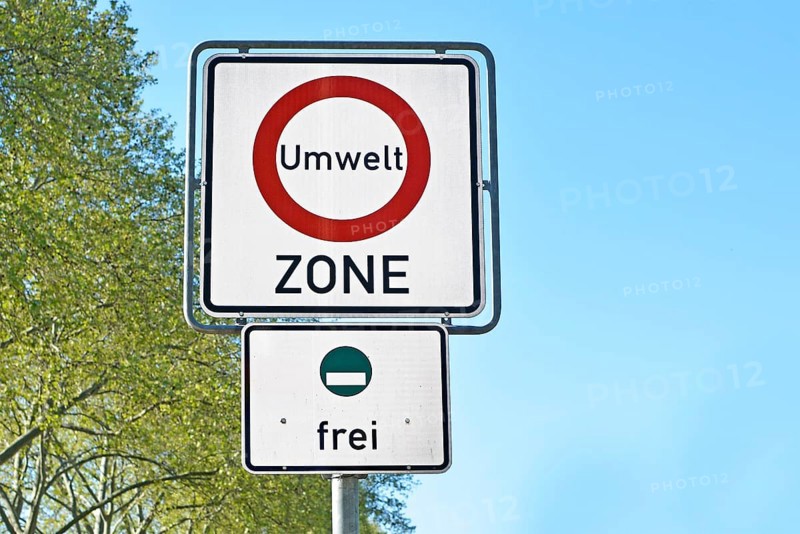 Road traffic sign marking a low emission zone in city centers in Germany translating as Environmental Zone and sign showing cars with green environmental badge a free to enter below