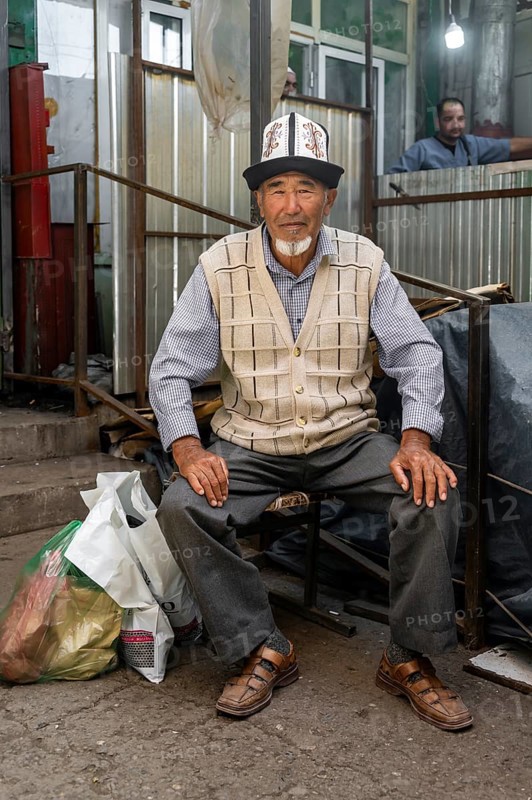 Man with traditional clothes shopping, market stall, Uzgen Bazaar, Ösgön, Osh region, Kyrgyzstan, Asia