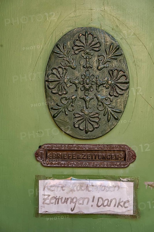 Oval carving and door slot with the inscription Letters & Newspapers as well as sign No free newspapers on the door leaf of a historic front door, heritage-protected building Fährstraße 6a from the 17th century, UNESCO World Heritage Site, historic old town Hanseatic city of Stralsund, Mecklenburg-Western Pomerania, Germany, condition 4 August 2021, Europe