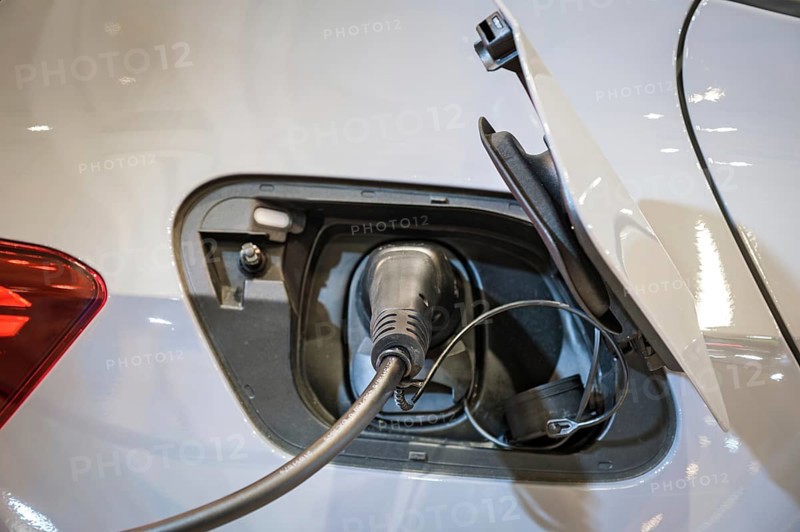 Ecology alternative green renewable clean sustainable energy zero emission concept. Electric vehicle charging port socket plug in EV modern electric vehicle car with charging cable close up