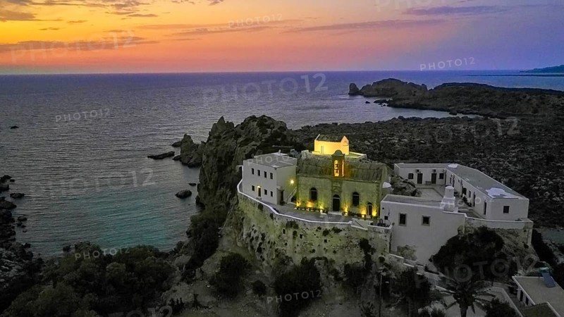 Drone shot, Gesmates Monastery, sea, illuminated church, illuminated chapel, dusk, sunset, cloudy sky, Chrissoskalitissa, rock monastery, Orthodox monastery, southwest tip, Chania province, Crete, Greece, Europe