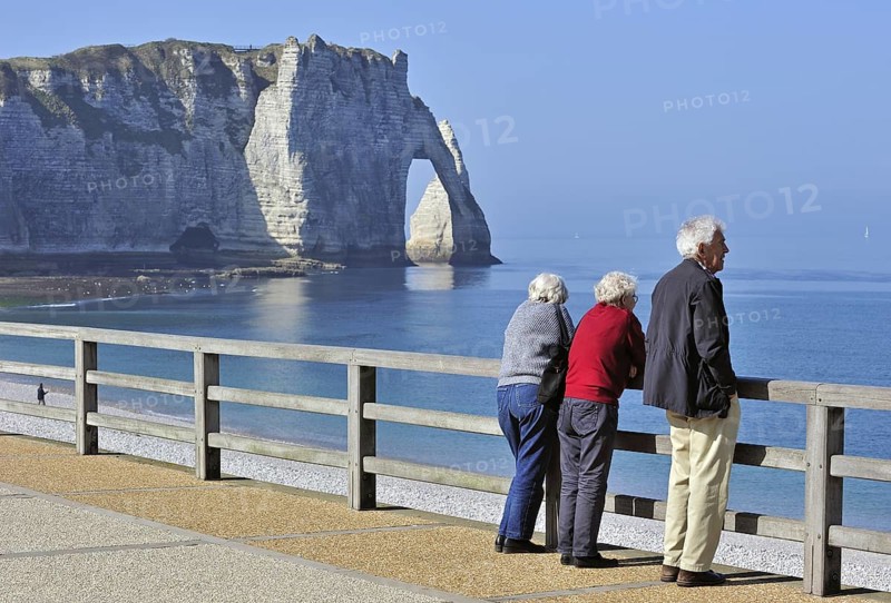 Elderly tourists and the Porte D'Aval, a natural arch in the chalk cliffs at Etretat, Côte d'Albâtre, Upper Normandy, France, Europe