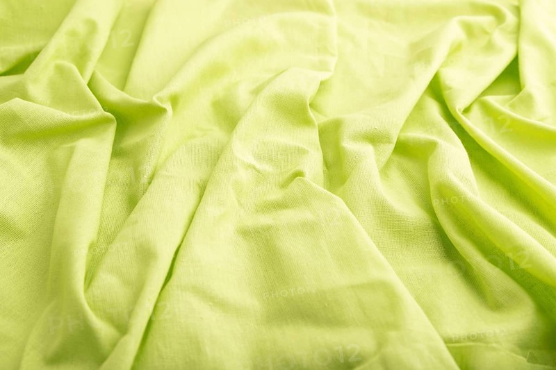 Fragment of green linen tissue. Side view, natural textile background and texture. wave concept, abstract