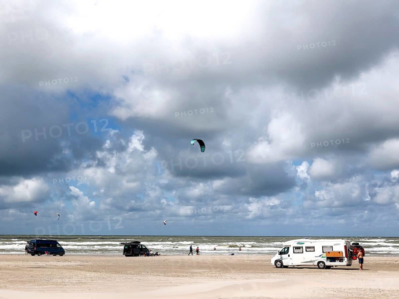 Motorhomes standing on Vejers beach in the North Sea, sail of a kite surfer, Vejers, Denmark, 17.07.2023, Europe