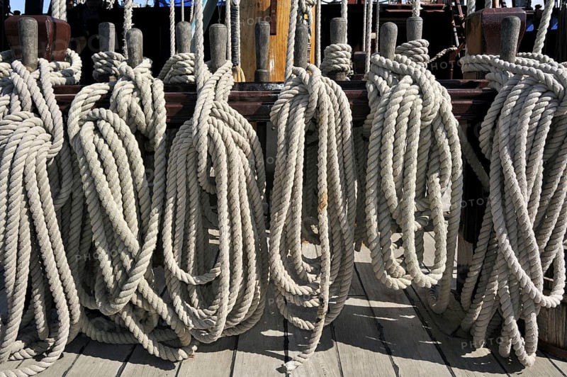 Ropes coiled around belaying pins aboard the Grand Turk, Etoile du Roy, a three-masted sixth-rate frigate replica of HMS Blandford, built in 1741 and based in Saint Malo, Brittany, France, Europe