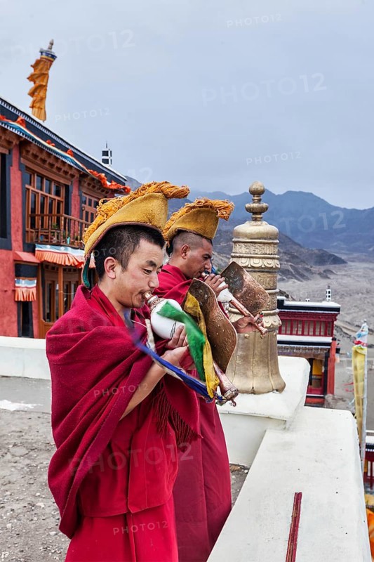 THIKSEY, INDIA, SEPTEMBER 4, 2011: Two Tibetan Buddhist monks blowing conches during morning pooja, Thiksey gompa, Ladakh, India, Asia