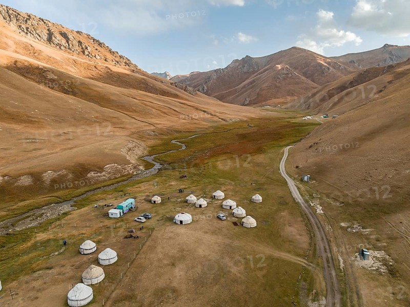 Aerial view, yurts in a mountain valley with a gravel road, Naryn region, Kyrgyzstan, Asia