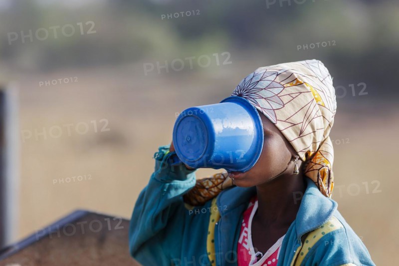 Young woman, girl drinking water from a plastic cup in Maraban Dare community in Plateau state, Nigeria, 07/02/2024, Africa