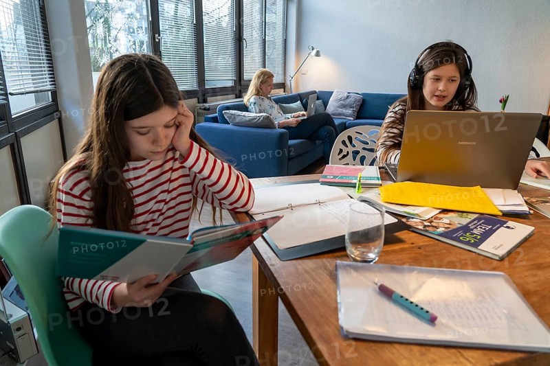 Homeschooling, during the lockdown in January 2021, children learning at home for school, a girl in video lessons with her class, her mother is in the home office and works on her laptop with video chat, school closures, distance learning, effects of the corona crisis in Germany