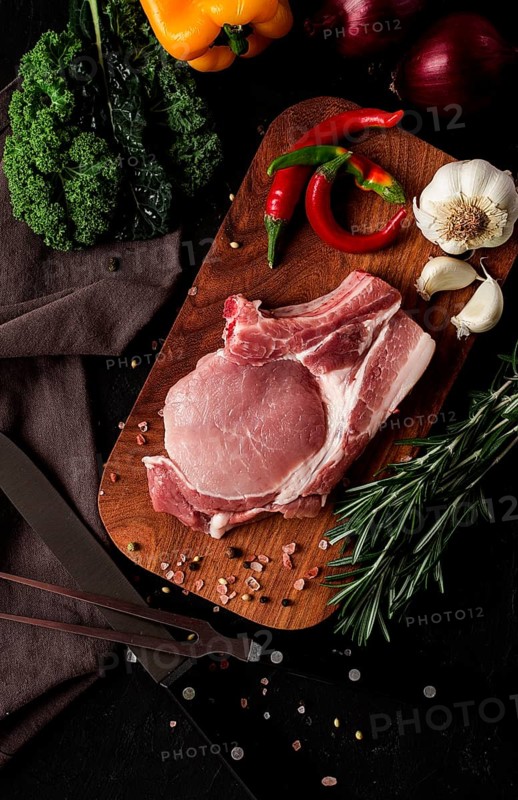 Raw pork meat, on a wooden board, close-up, vertical, no people, selective focus, rustic, serving, sliced