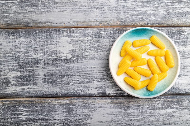 Jelly corn candies on gray wooden background. top view, flat lay, copy space