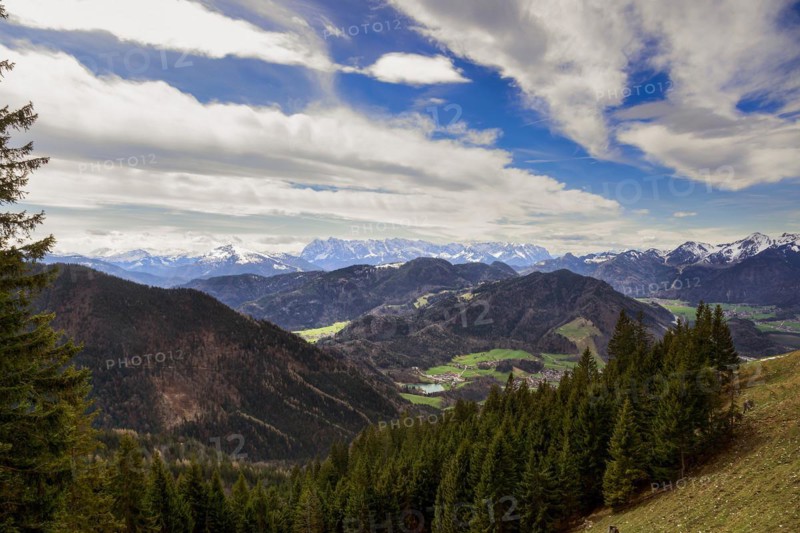 Panoramic view of the snow-covered Chiemgau mountains and green hills above the village of Unterwössen in the Chiemgau Alps Bavaria Germany Europe