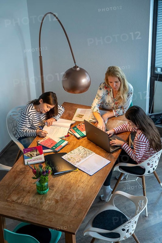Homeschooling, during the lockdown in January 2021, mother helps her two daughters, at home, learning, with textbooks and computers, school closures, distance learning, effects of the corona crisis in Germany