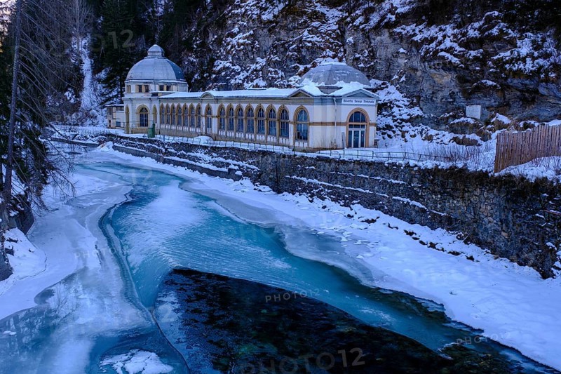 Büvetta Tarasp drinking hall on the Inn or En, Nairs near Scuol in winter, with ice floes, Engadin, Graubünden, Switzerland, Europe